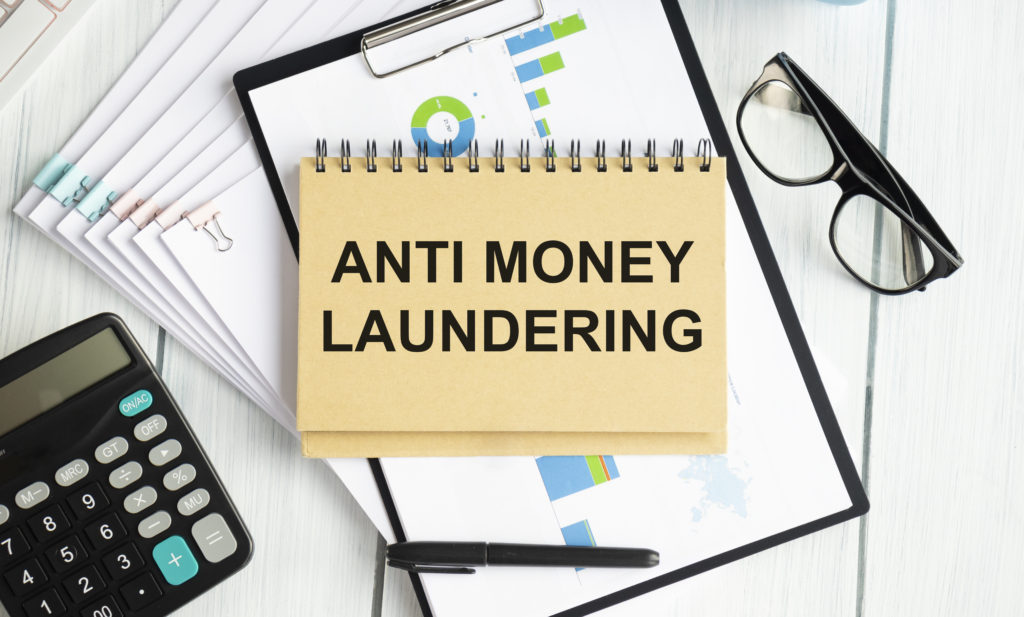 Paper with text AML Anti Money Laundering on a table